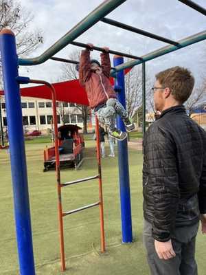 Avery swinging from the monkey bars